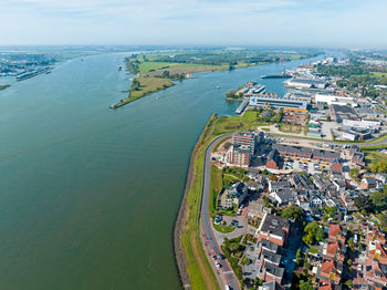 High angle view of city by sea against sky