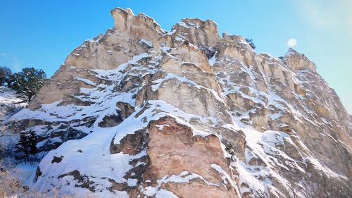 Low angle view of snowcapped mountain against clear sky