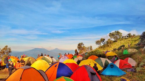 Tents and people on mountains against sky