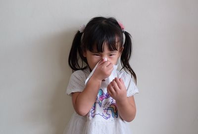 Cute girl standing against wall