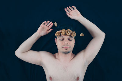 Man wearing flowers sleeping on bed