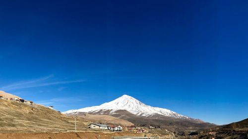 Scenic view of snowcapped mountains against blue sky