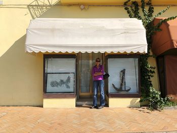 Woman standing against front door of store