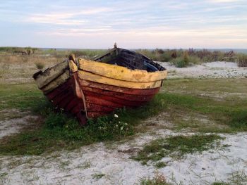 Abandoned boat on shore against sky