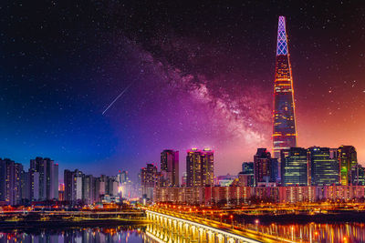 Low angle view of illuminated buildings against sky at night