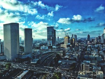 High angle view of skyscrapers against cloudy sky