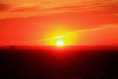 Scenic view of landscape against orange sky