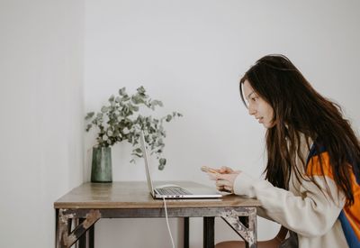 Side view of young woman looking at home