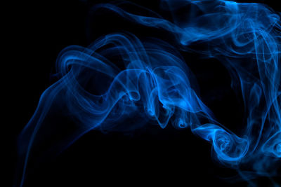 Close-up of blue smoke against black background