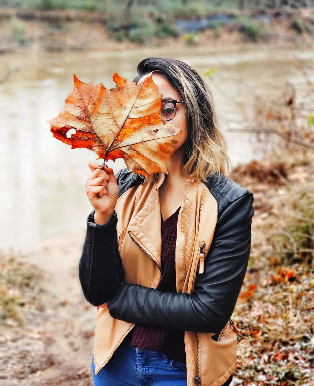 autumn, leaf, plant part, one person, real people, leisure activity, young women, young adult, change, nature, focus on foreground, day, holding, lifestyles, dry, front view, land, casual clothing, portrait, hair, outdoors, beautiful woman, hairstyle, leaves, scarf, maple leaf