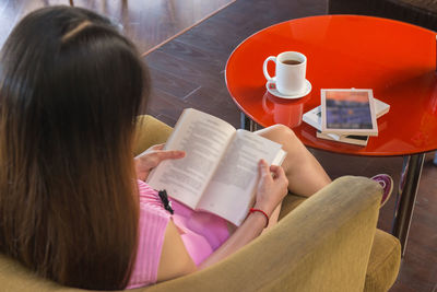 Rear view of woman reading book