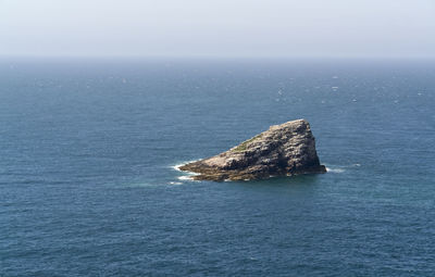 Scenic view of rocks in sea against sky