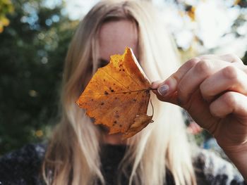 Close-up of hand holding autumn leaf