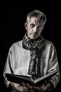 Portrait of mid adult woman against black background