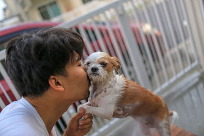 Side view of man kissing dog