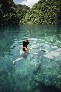 Carefree young woman swimming in sea