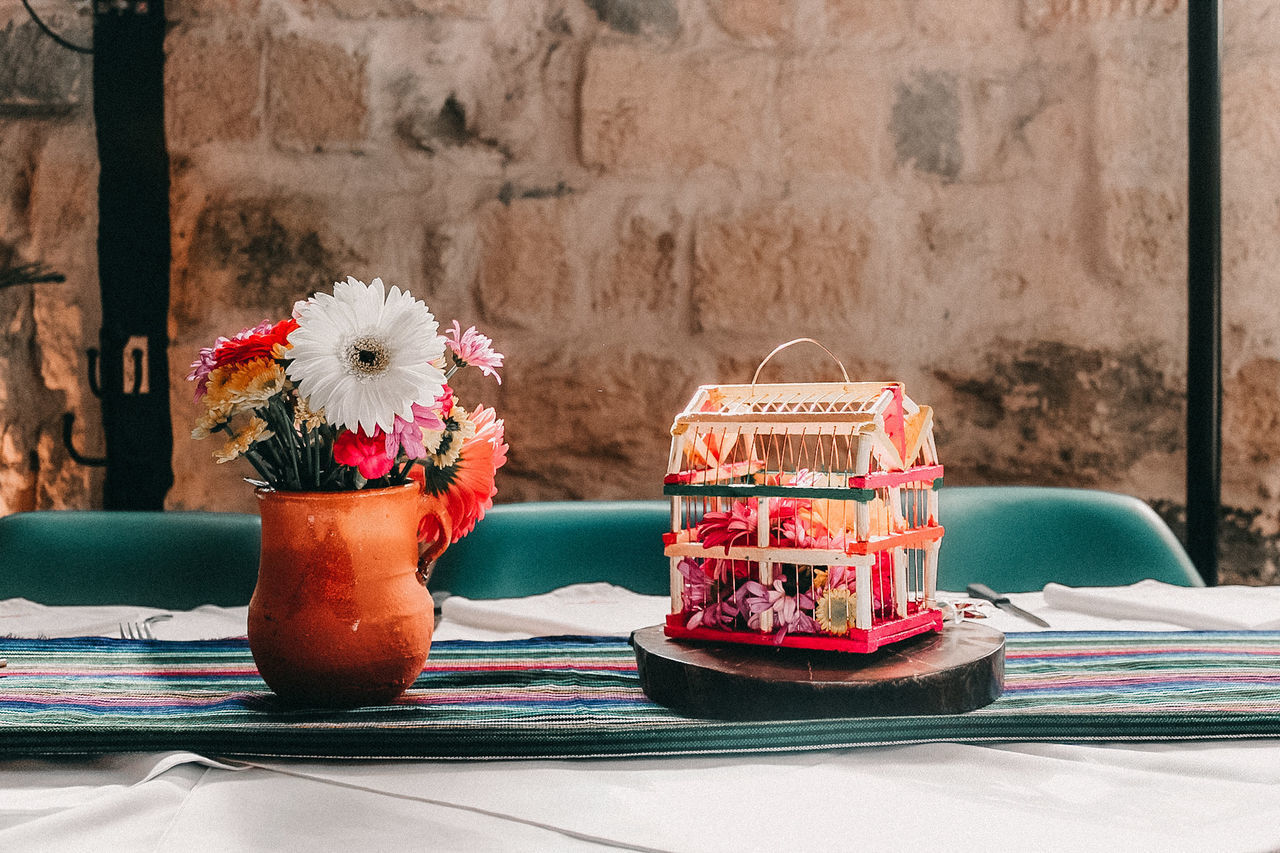 CLOSE-UP OF VARIOUS FLOWERS IN VASE ON TABLE