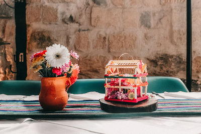 Close-up of roses in vase on table against wall