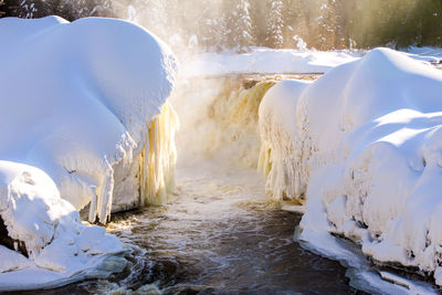 Frozen river amidst snowcapped mountains