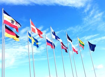Low angle view of flags against blue sky