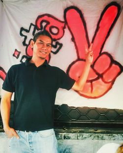 Full length of young man standing against wall