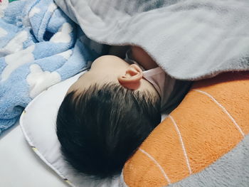 High angle view of baby boy sleeping on bed at home