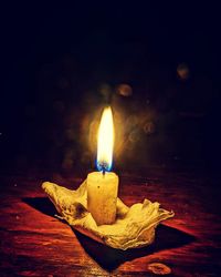 Close-up of lit candle in dark room