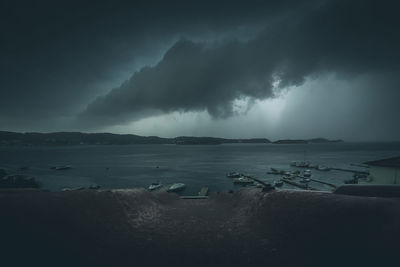 Scenic view of sea against storm clouds