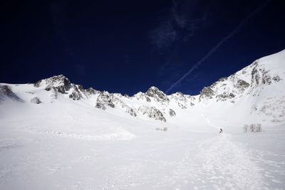 People skiing on snowcapped mountain against sky