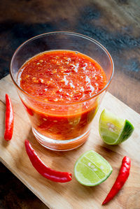 Sweet chili sauce in the glass on wooden table.