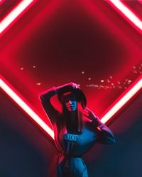 Full length of woman photographing illuminated red light