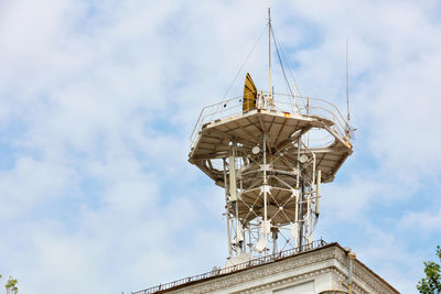 A metal structure rises on the roof of the house with various cellular and satellite antennas .