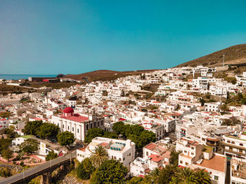 Buildings in town against clear blue sky