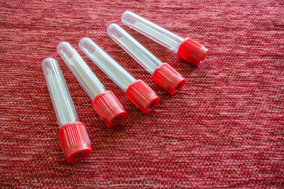 Close-up high angle view of medical supplies on red textile