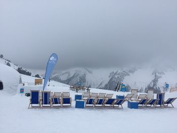 Scenic view of chairs on snowcapped mountain