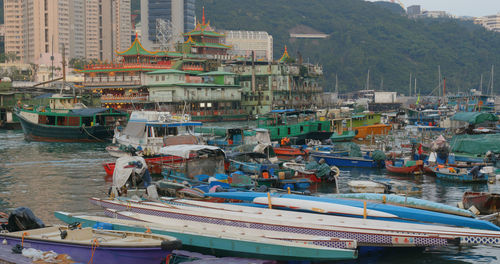 Boats moored at harbor by buildings in city