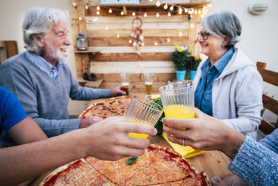 Man and woman holding food while sitting outdoors