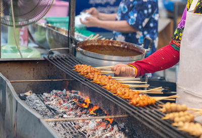 Chef grilled meat ball with sauce on charcoal in street food market.