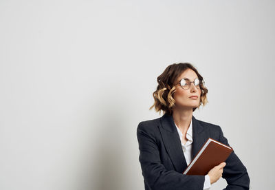 Mid adult woman looking away over white background