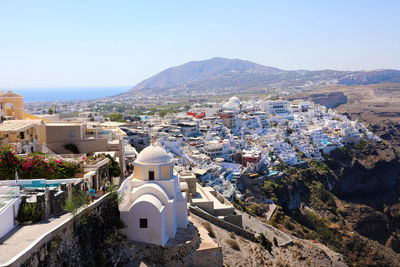 Aerial view of townscape and mountains against clear sky