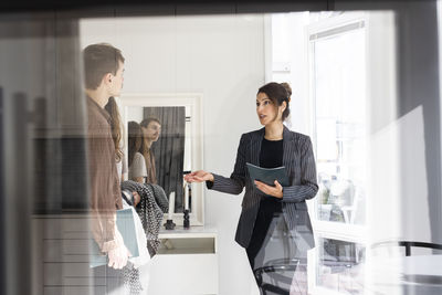 Saleswoman discussing with customers during house visit