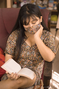 Midsection of woman sitting against wall