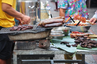 Midsection of man preparing food on barbecue grill