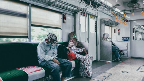 Rear view of people sitting in train