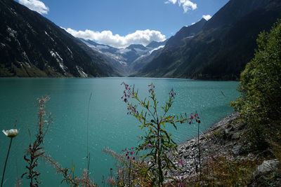 Scenic view of lake by mountains against sky