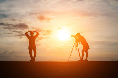 Man and woman with camera during sunset
