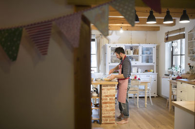 Man standing in kitchen, preparing cake dough