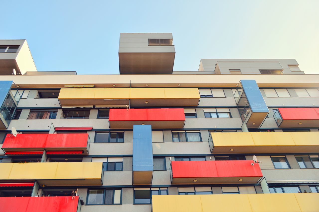 building exterior, architecture, built structure, low angle view, balcony, no people, clear sky, outdoors, day, city, multi colored, sky