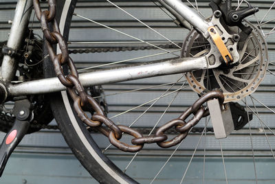 Cropped image of chain locked on bicycle wheel