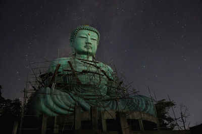 Low angle view of statue against sky at night